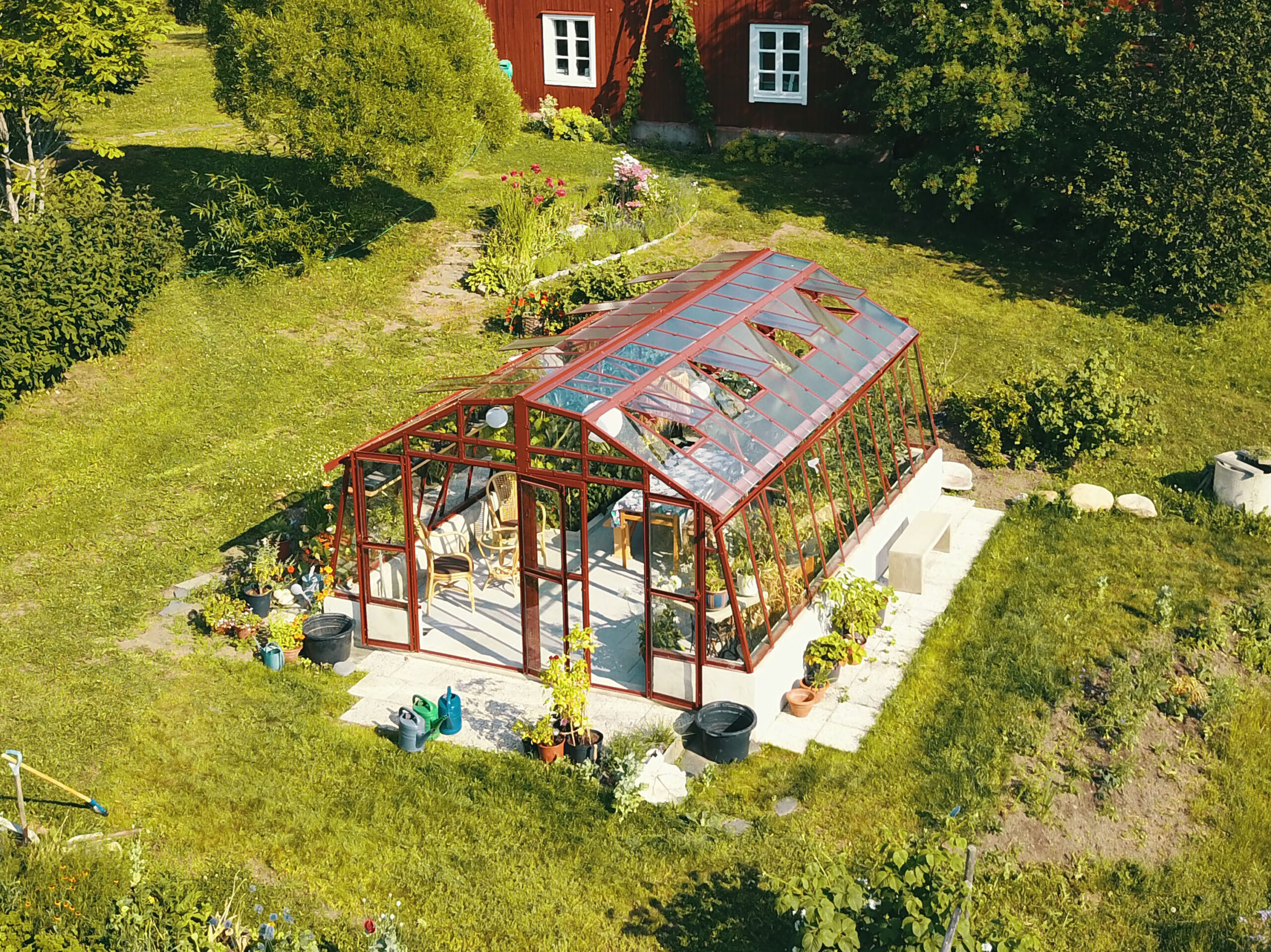 Variant 426 mur 60 lackering röd i en svensk trädgård.